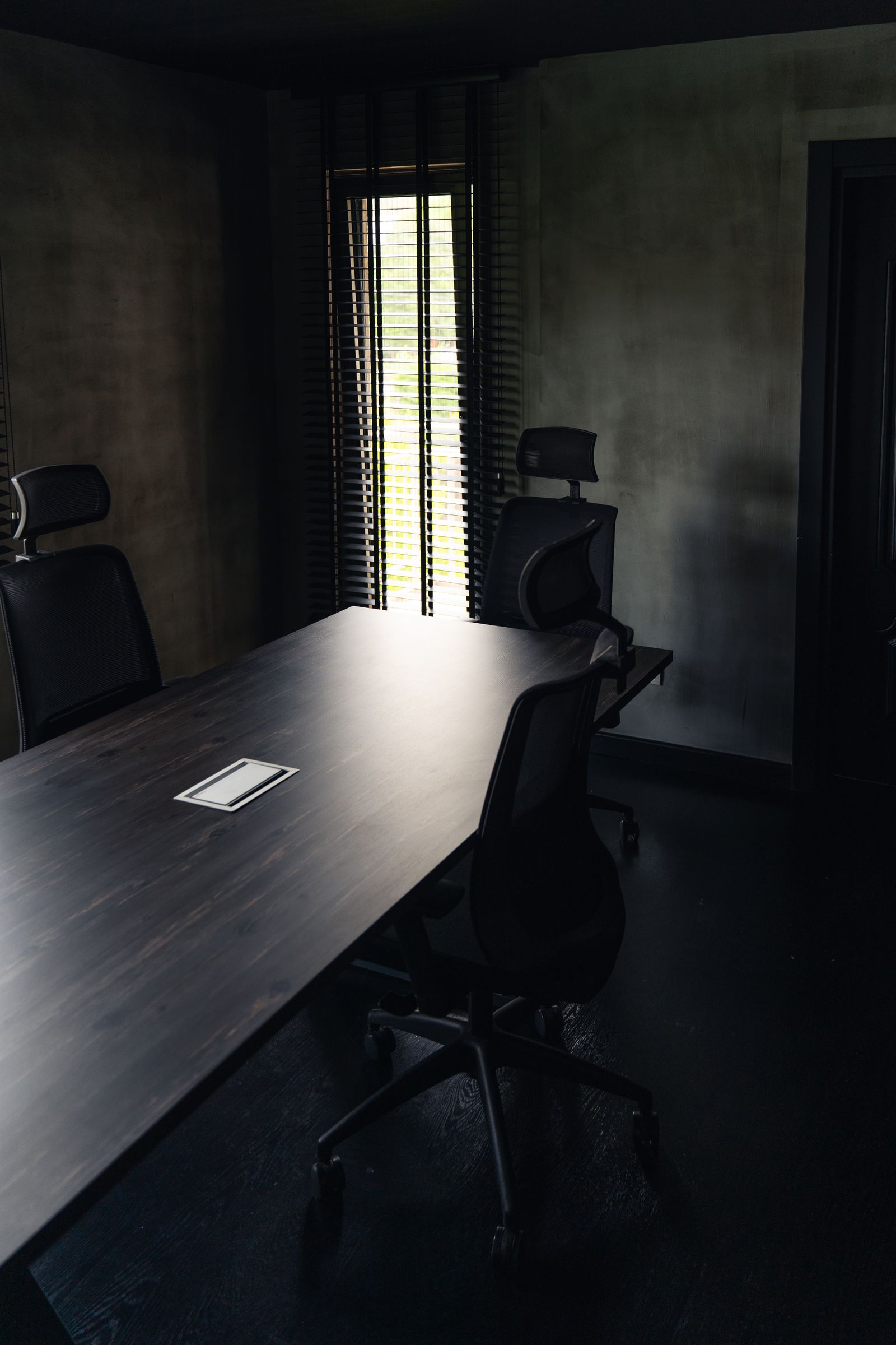 Quiet executive boardroom with a single shaft of light
